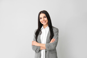 Beautiful young businesswoman on grey background