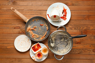 Dirty kitchenware and tableware on wooden background
