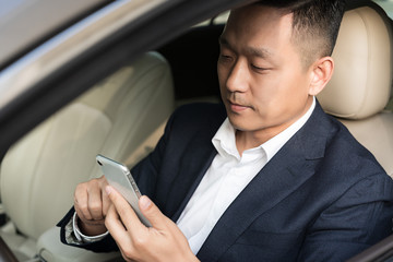 Asian business man on the phone in the car