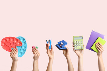 Many hands with school supplies on light background