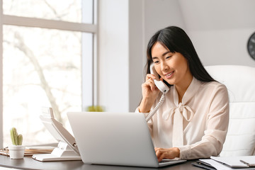Beautiful Asian secretary working in office