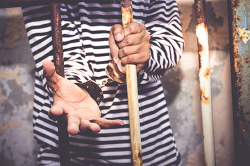 Robbers in black and white striped shirts were handcuffed in the prison cell. Security and property...