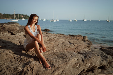 Outdoor portrait of young beautiful woman with long hair on the sea beach.