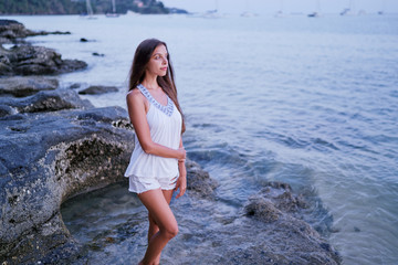 Outdoor portrait of young beautiful woman with long hair on the sea beach.