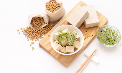 Diced soy cheese Tofu, Microgreens on wooden board with chopsticks