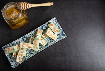 Homemade pistachio nougat on a dark rustic background top view.