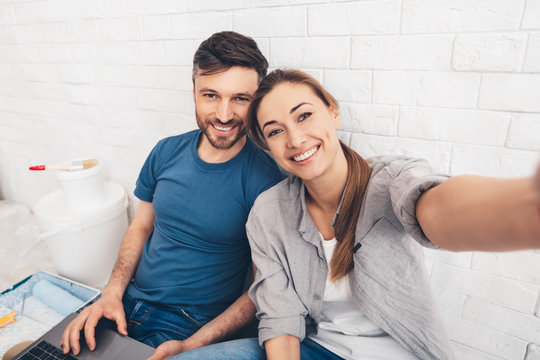 Happy young couple sitting in new apartments