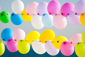 Colorful balloons tied on strings, waiting to be popped by shooters in a game on the shore of the...
