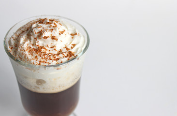 A view of a cappuccino in a cup, shot from above. The cup shows cream in the cup