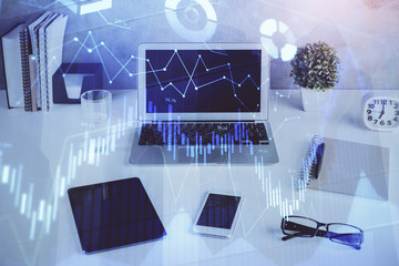 Stock market graph on background with desk and personal computer. Multi exposure. Concept of financial analysis.