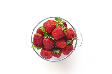 Juicy ripe strawberries in a bowl, isolated on a white background with space for text. Side view