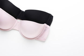 Set of nude and black strapless bandeau bra. Balconette bra on white background.Basic beige and...