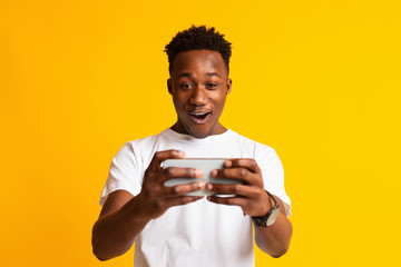 Excited african american man playing online games © Prostock-studio