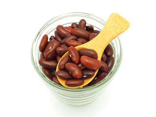 Kidney red beans in wooden spoon over glass cup isolated on white background. High protein. Close up, Top view.