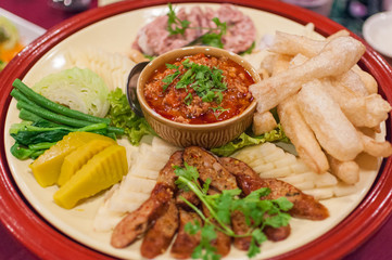 plate with the traditional Northern Thai food dish Nam Prik (น้ำพริก), steamed Vegetables and Sai Oua sausage (ไส้อั่ว) in Chiang Mai