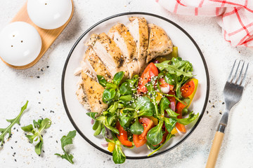 Baked chicken with fresh salad top view.