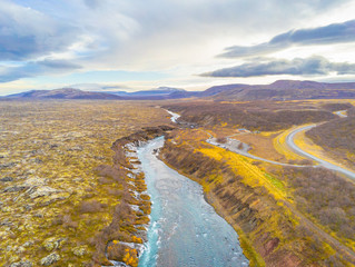 Hraunfossar series of waterfalls barnafoss aerial image of turquoise water streaming down gaps in...