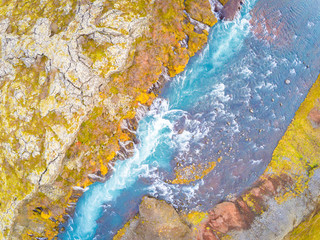 Hraunfossar series of waterfalls barnafoss aerial image of turquoise water streaming down gaps in lava collecting in plunge pool