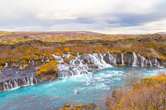 Hraunfossar series of waterfalls barnafoss turquoise water collecting into plunge pool during autumn