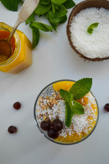 Foodfoto Chia pudding with coconut shavings, orange tangerine curd, mint and berries.