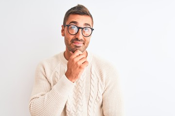 Young handsome man wearing glasses and winter sweater over isolated background serious face...