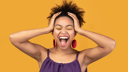 Happy afro woman screaming and grabbing head