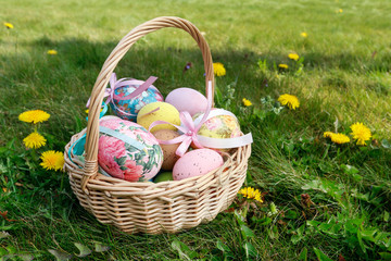 Wicker basket with Easter eggs in the garden.