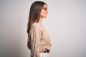 Young beautiful brunette businesswoman wearing casual sweater and glasses standing looking to side, relax profile pose with natural face with confident smile.