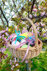 Fototapeta na wymiar Wicker basket with Easter eggs in the garden.