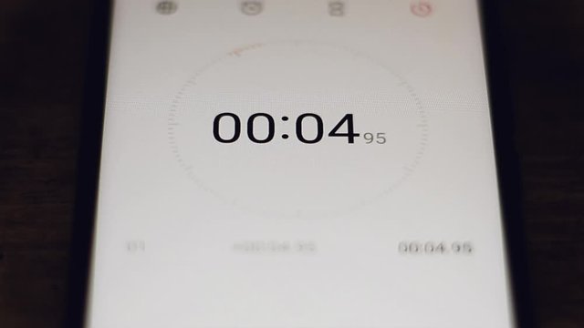 The stopwatch in the hands of a woman counts to 10 and the girl stops him