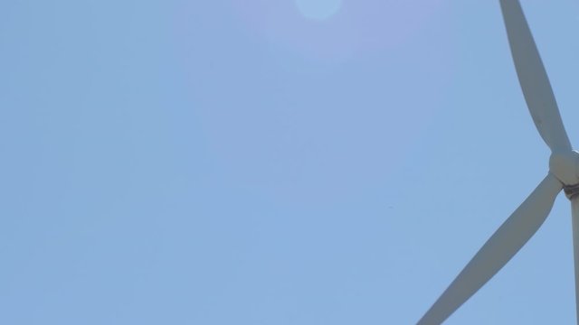 Blades of a wind turbine of renewable energy moving a sunny day with blue sky