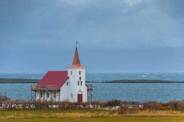 Fototapeta na wymiar Wooden church in Iceland close to Atlantic coast during stormy weather