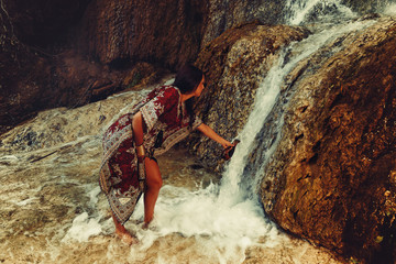 woman with carafe in beautiful oriental dress in water.