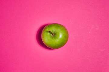 Green apple on pink background. Flat lay, top view, copy space . Food dietary concept.