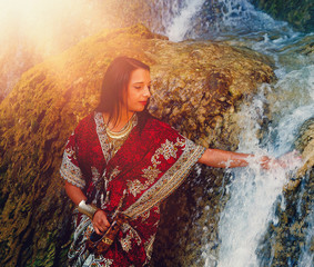 woman with carafe in beautiful oriental dress in water.