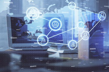 Computer on desktop with social network hologram. Multi exposure. Concept of international people connections.
