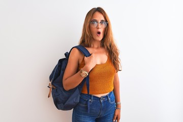 Young redhead student woman wearing glasses and backpack over isolated background scared in shock with a surprise face, afraid and excited with fear expression
