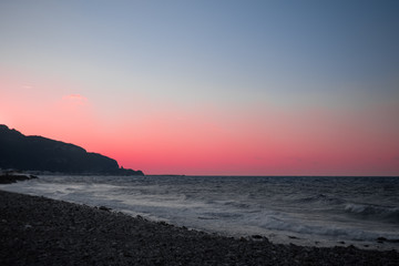 pink sunset overlooking the wavy sea