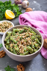 Salad with green beans and spicy walnut sauce in a bowl. Vegetarian, vegan menu.