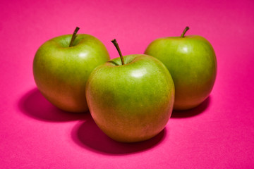 Green apple on pink background. Flat lay, top view, copy space . Food dietary concept.