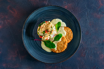 Top view of pike cutlet with rice, green bean and bell pepper with cream sauce