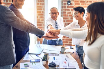 Group of business workers standing with hands together at the office