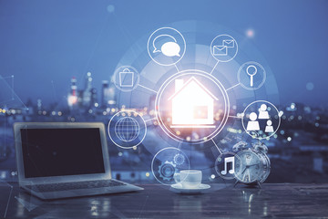 Desktop computer background in office and big town buildings hologram drawing. Double exposure. Smart city concept.