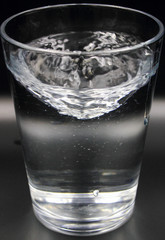 swirling spinning water in a glass with bubbles isolated on a black background