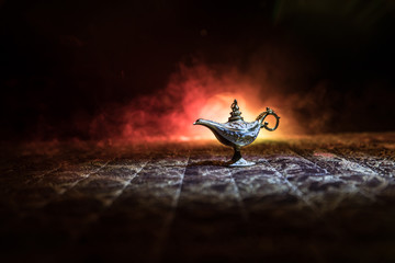 Lamp of wishes concept. Antique Aladdin arabian nights genie style oil lamp with soft light white...
