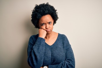 Fototapeta na wymiar Young beautiful African American afro woman with curly hair wearing casual sweater thinking looking tired and bored with depression problems with crossed arms.