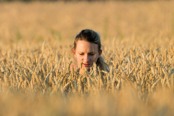 Naklejka na ściany i meble Girl in a dress in a wheat field