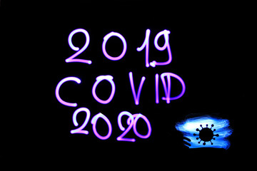 Inscription "2019 covid 2020" from corona virus. Made with lightpainting with an electric lamp. Symbol of a biological cell.