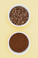 Coffee beans in the bowl. Ground coffee in a bowl. Yellow background.