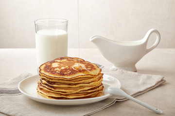 Sweet homemade stack of pancakes with jam and maple syrup for Breakfast with milk